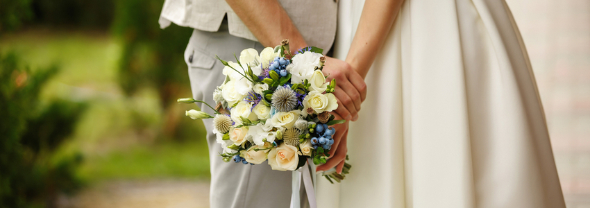 Wedding bouquet in the hands of a bride and groom.