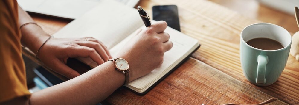 A woman making notes in a diary.